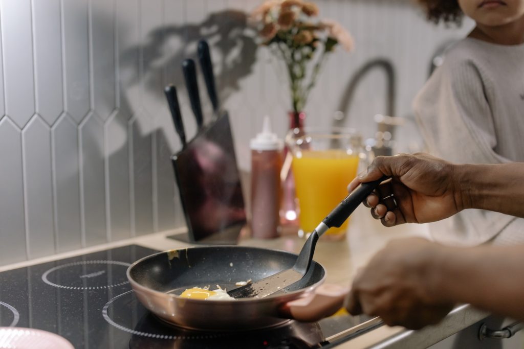 Close-Up Shot of a Person Cooking an Egg