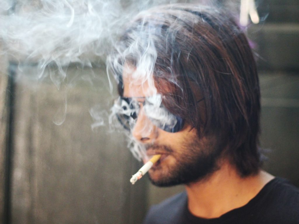 selective focus photography of smoking man